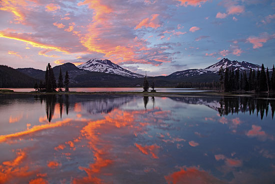 Fiery Sunset colors over glaciers of South Sister, Broken Top Mountain and Sparks Lake Cascade Lakes Oregon.